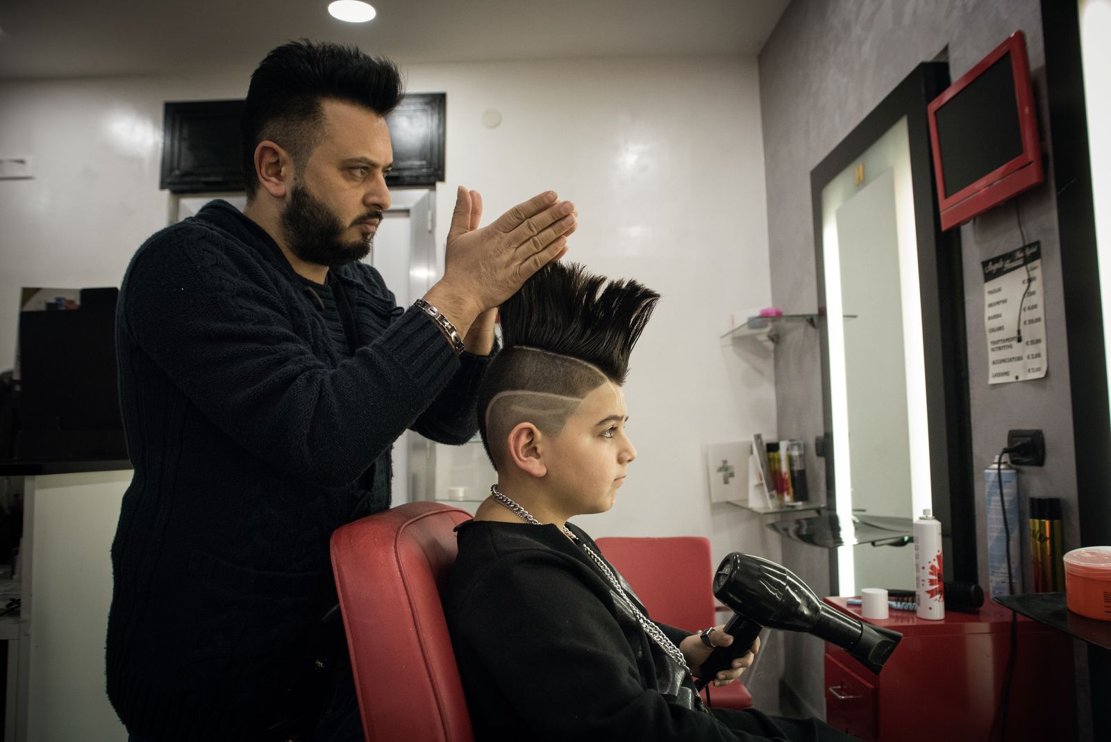 © Camillo Pasquarelli - Angelo Ferrara, Luciano's manager, prepares his son's haistyle inside the beauty salon he runs in Frignano.