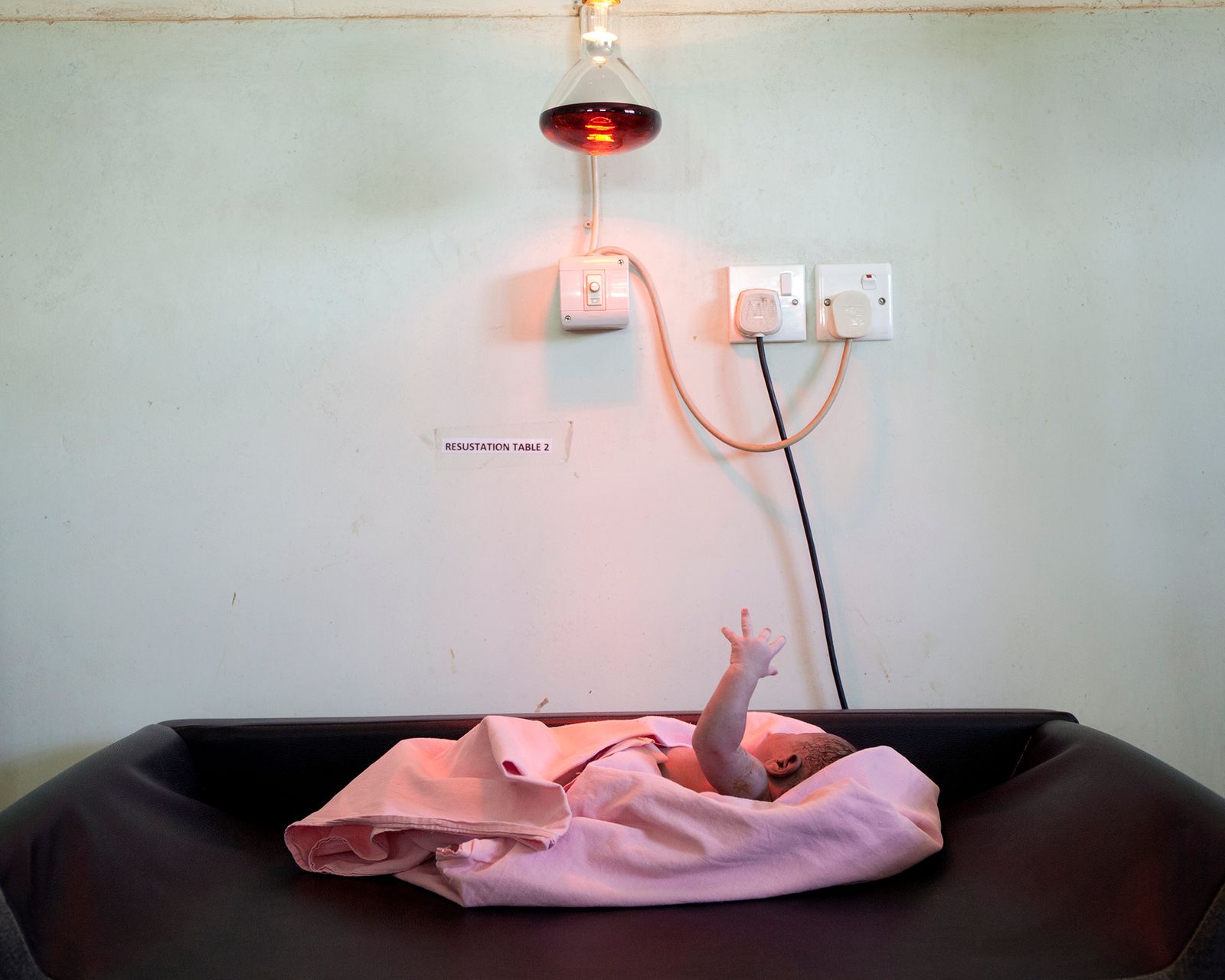 © Valeria Scrilatti - Karamoja region (Uganda). Matany Hospital: a newborn under the heat lamp in the delivery room.