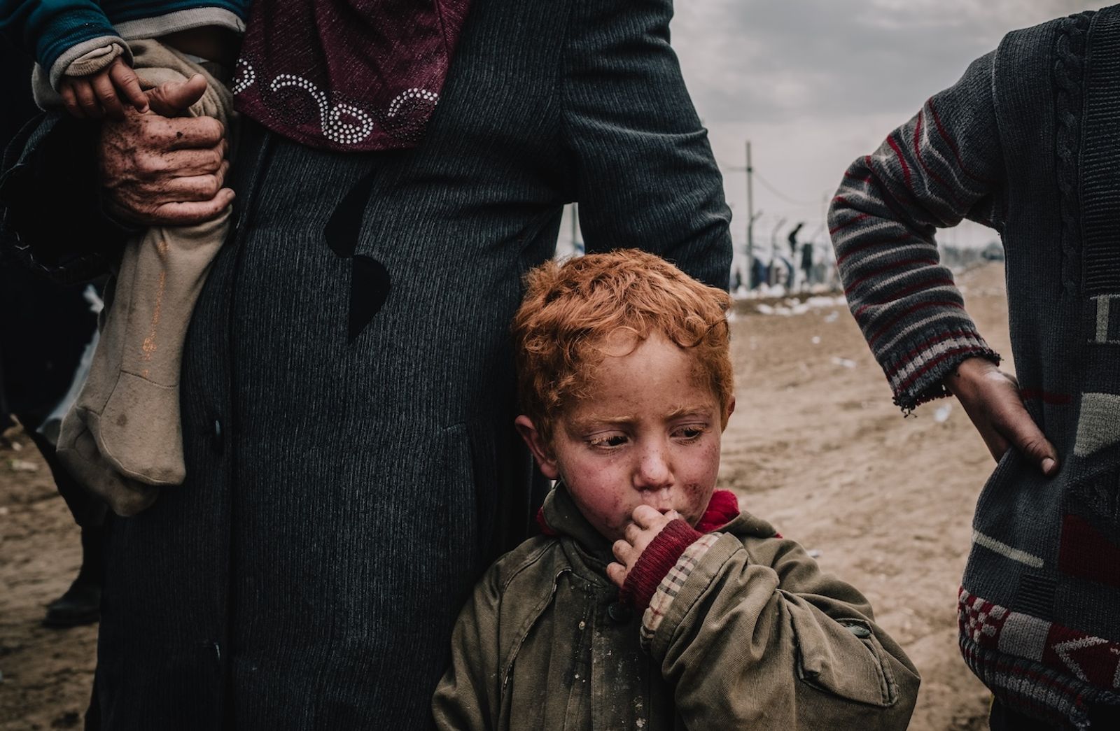 © Alexandra Howland - A family waits for medical treatment after arriving to Hamam al-Alil camp.