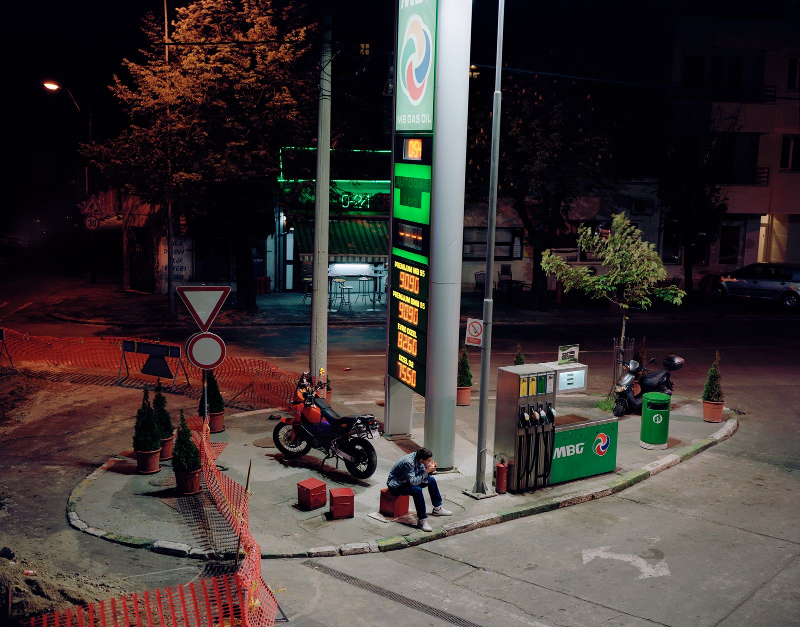 © Andy Ash - Bojan (Bobby) smokes a cigarette next to the petrol pump as he is a self-proclaimed " crazy Serb"