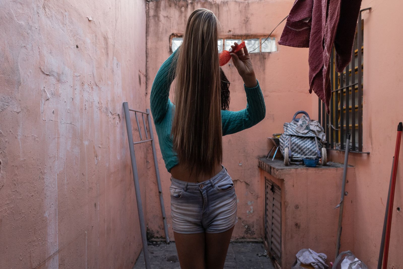 © Dan Agostini - Celina combs a wig in the house where she lives in São Paulo.