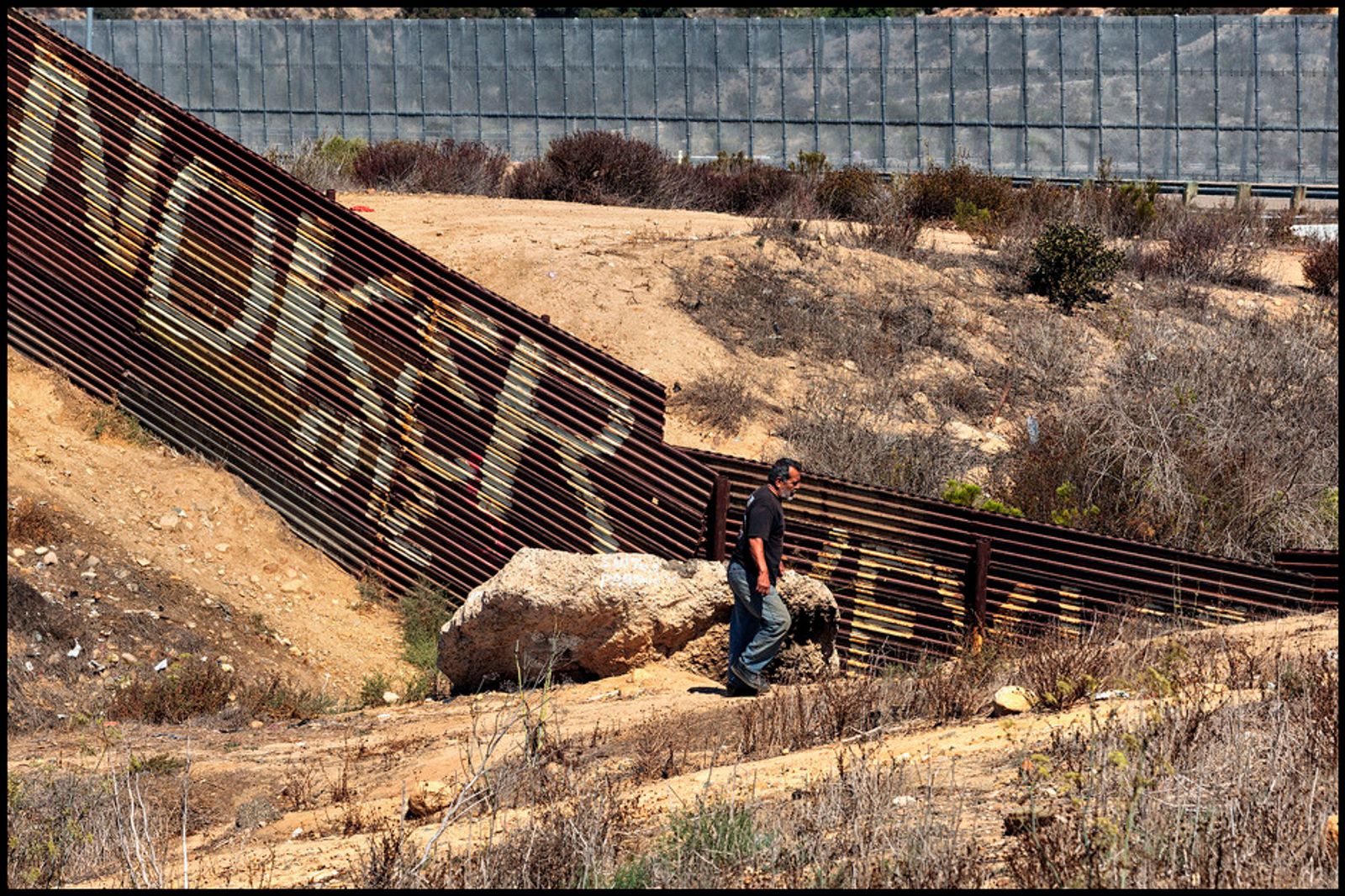 © Prometeo Lucero - Un hombre camina al lado del muro fronterizo en Tijuana.