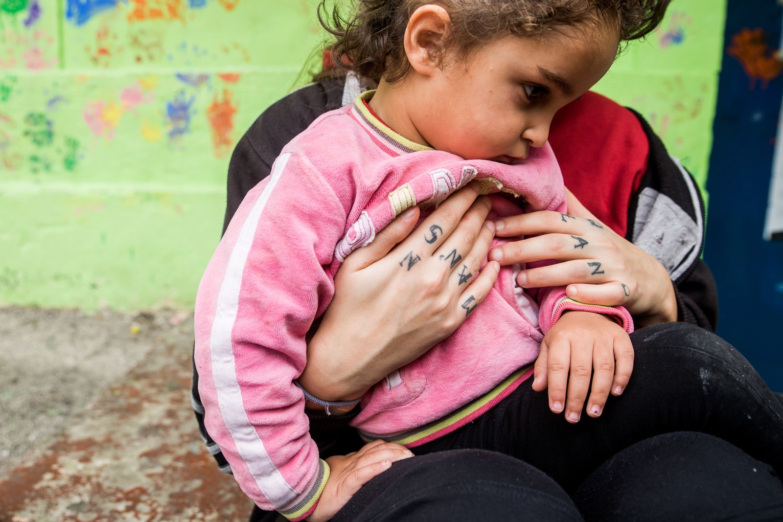 © Zoltán Balogh - A volunteer holds a refugee child on the yard of a squat home named 5th School in Athens, Greece, 04 December 2016.