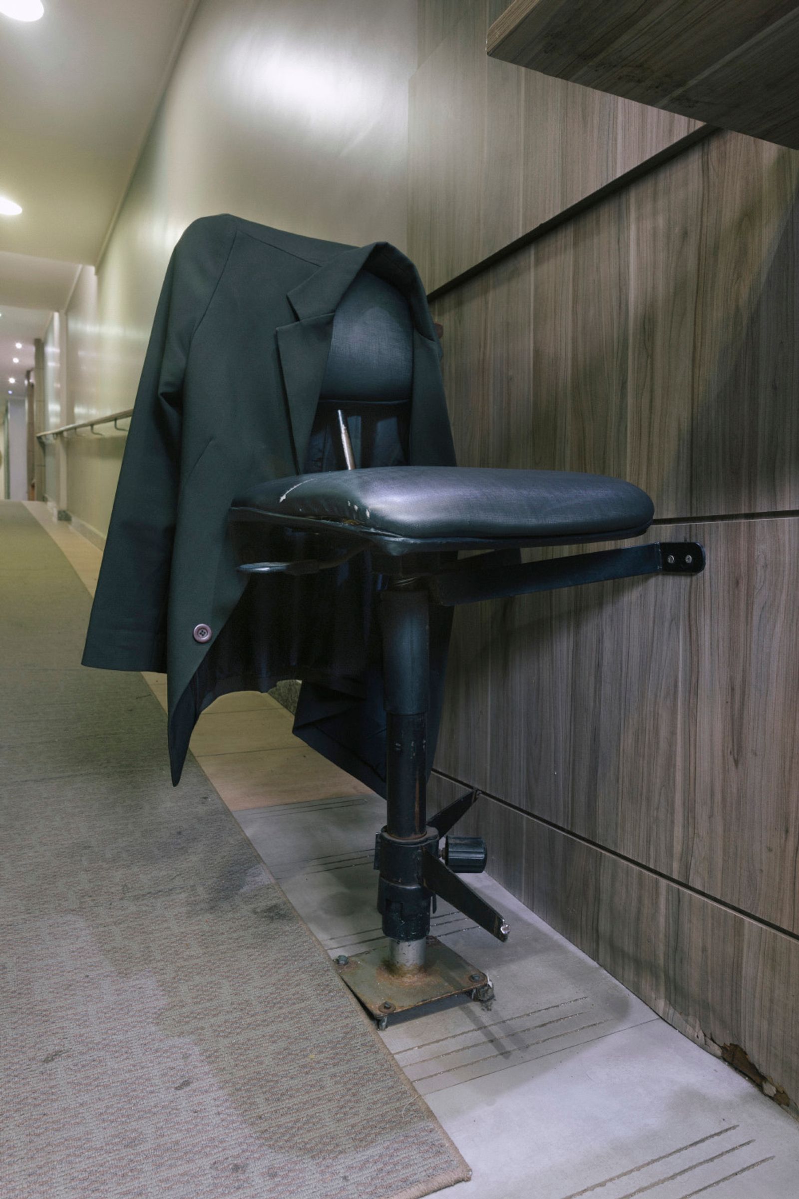 © Gabriel Carpes - An empty chair where a doorman sits at an apartment building.