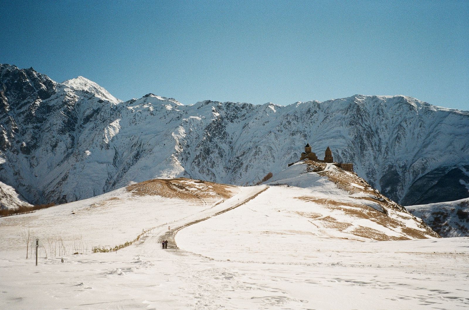 © Ika Margania - Gergeti Trinity Church and two strangers on the road. 2170 meters (7120 feet) above the sea level