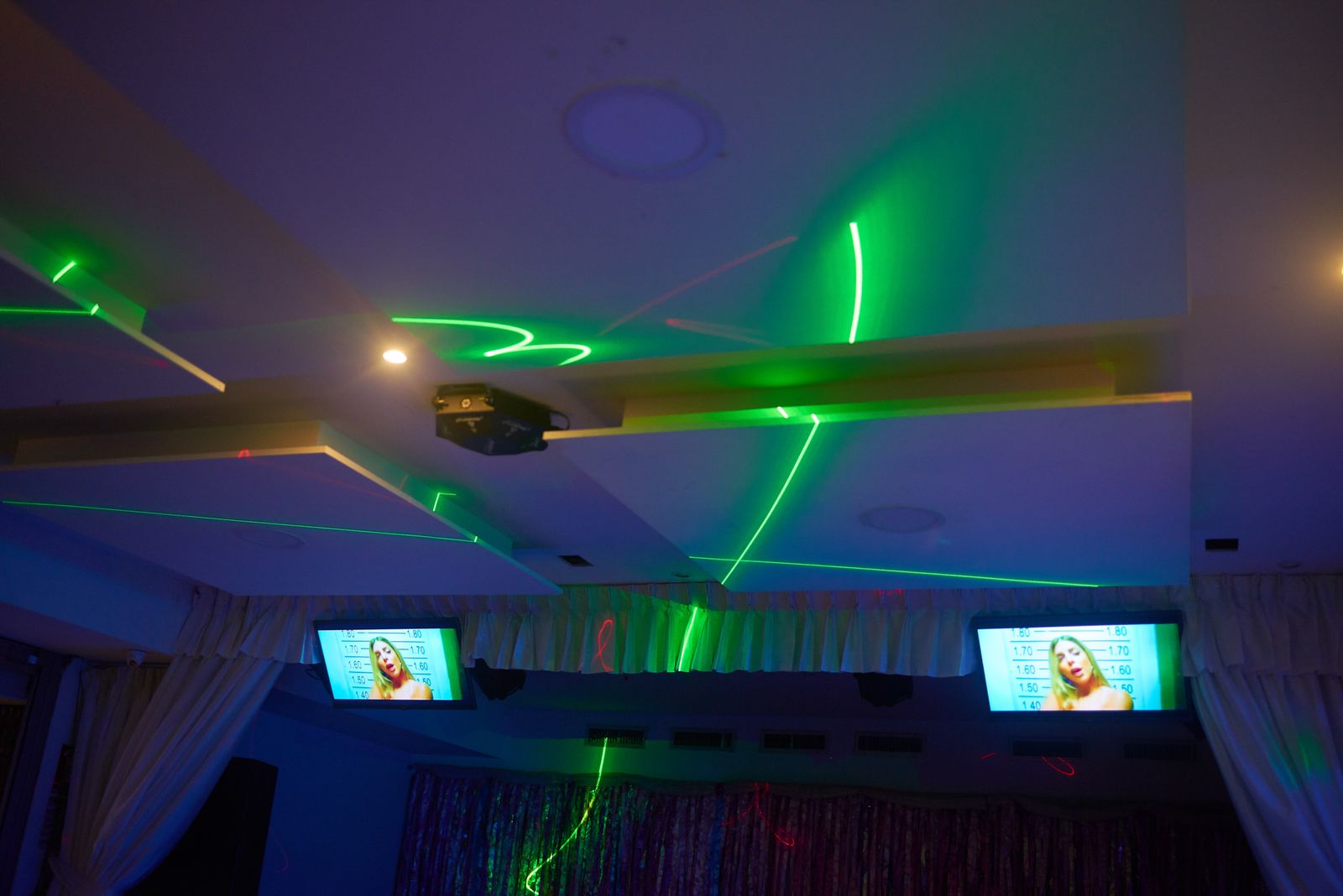 © Lexi Parra - Neon colors and TVs illuminate the otherwise dark, small club.