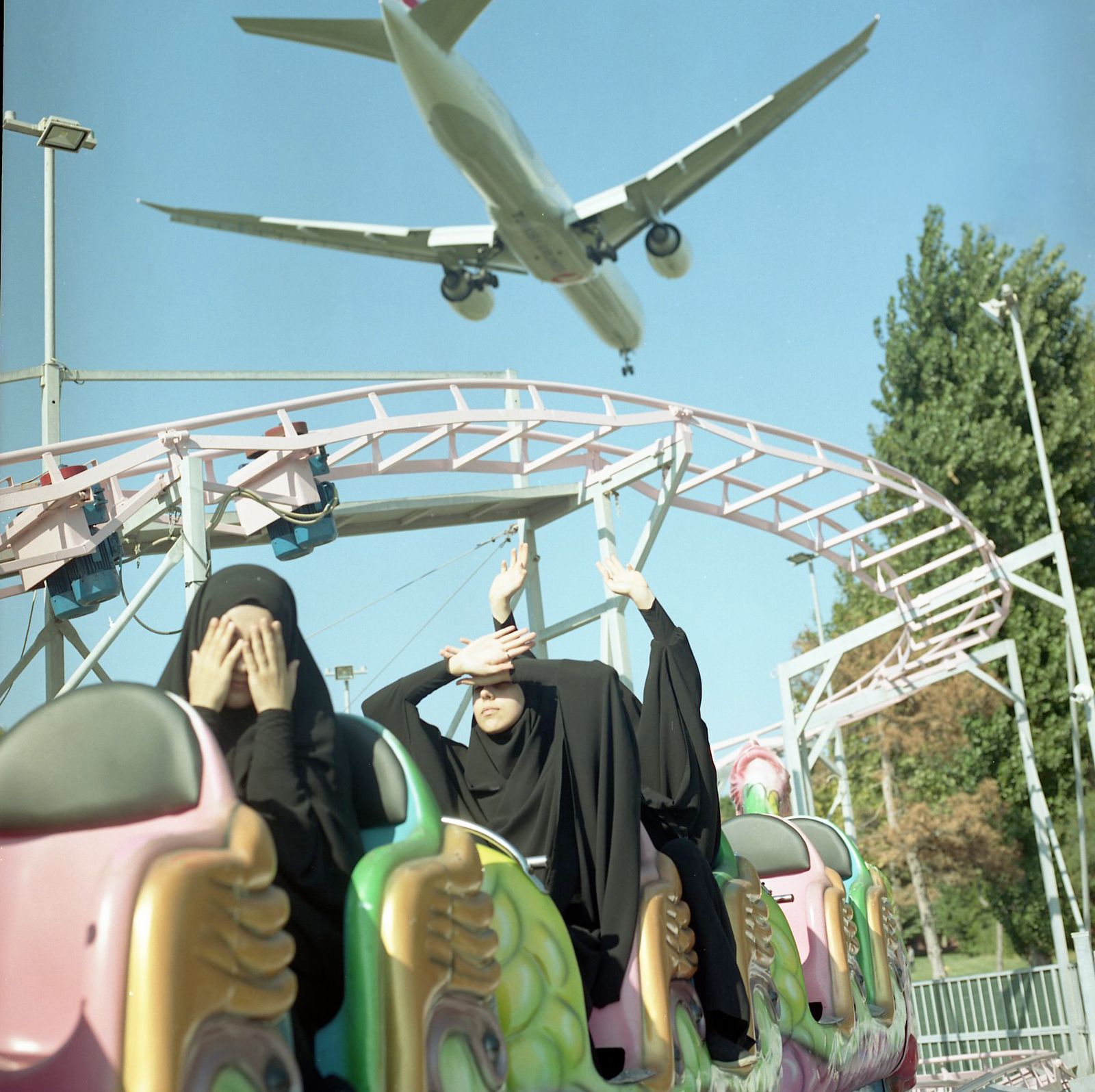 © Sabiha Çimen - Funfair. Turkey-Istanbul On the weekend girls are on the train at the fun fair and low-level plane passing by.