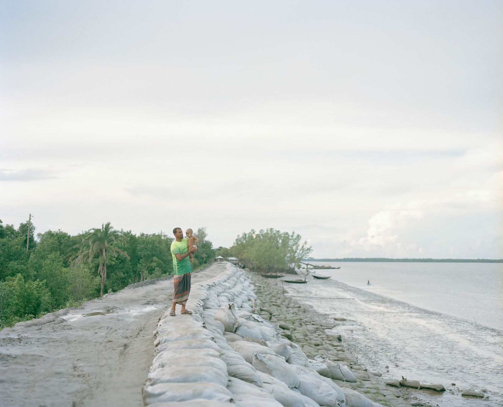 © Shunta Kimura - A man is looking after his baby by the Kholpetua River.