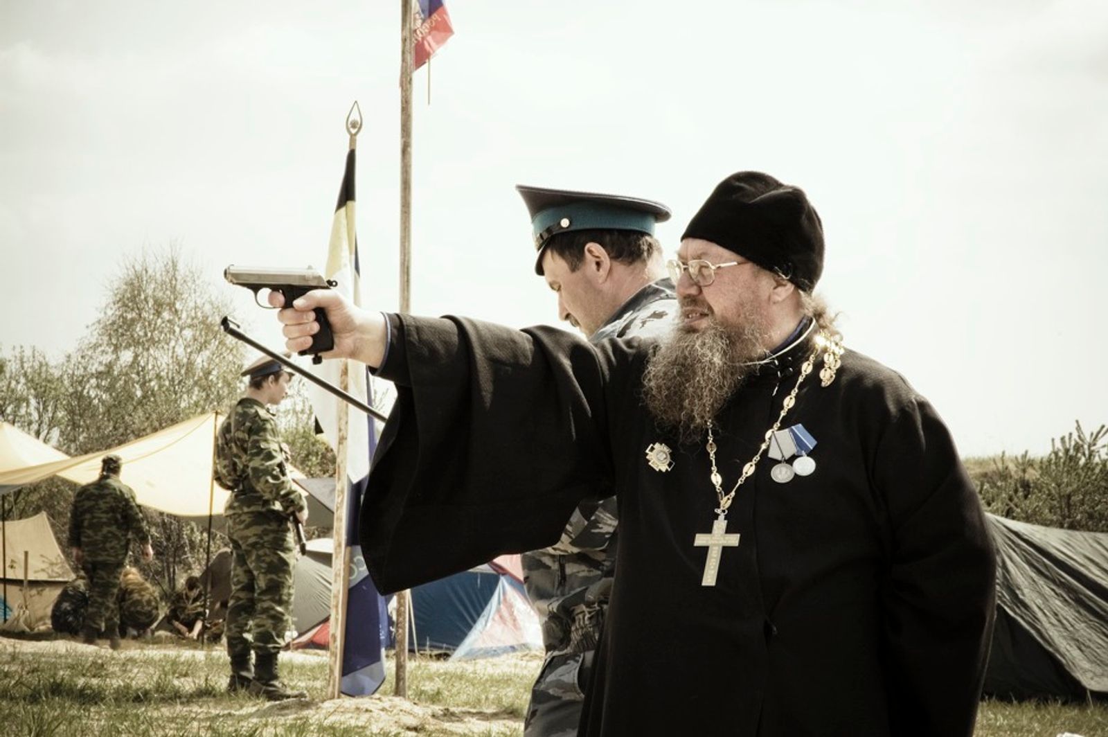 © Denis Tarasov - A priest of the Russian Orthodox Church firing a hand gun. Sverdlovsk region, Russia.