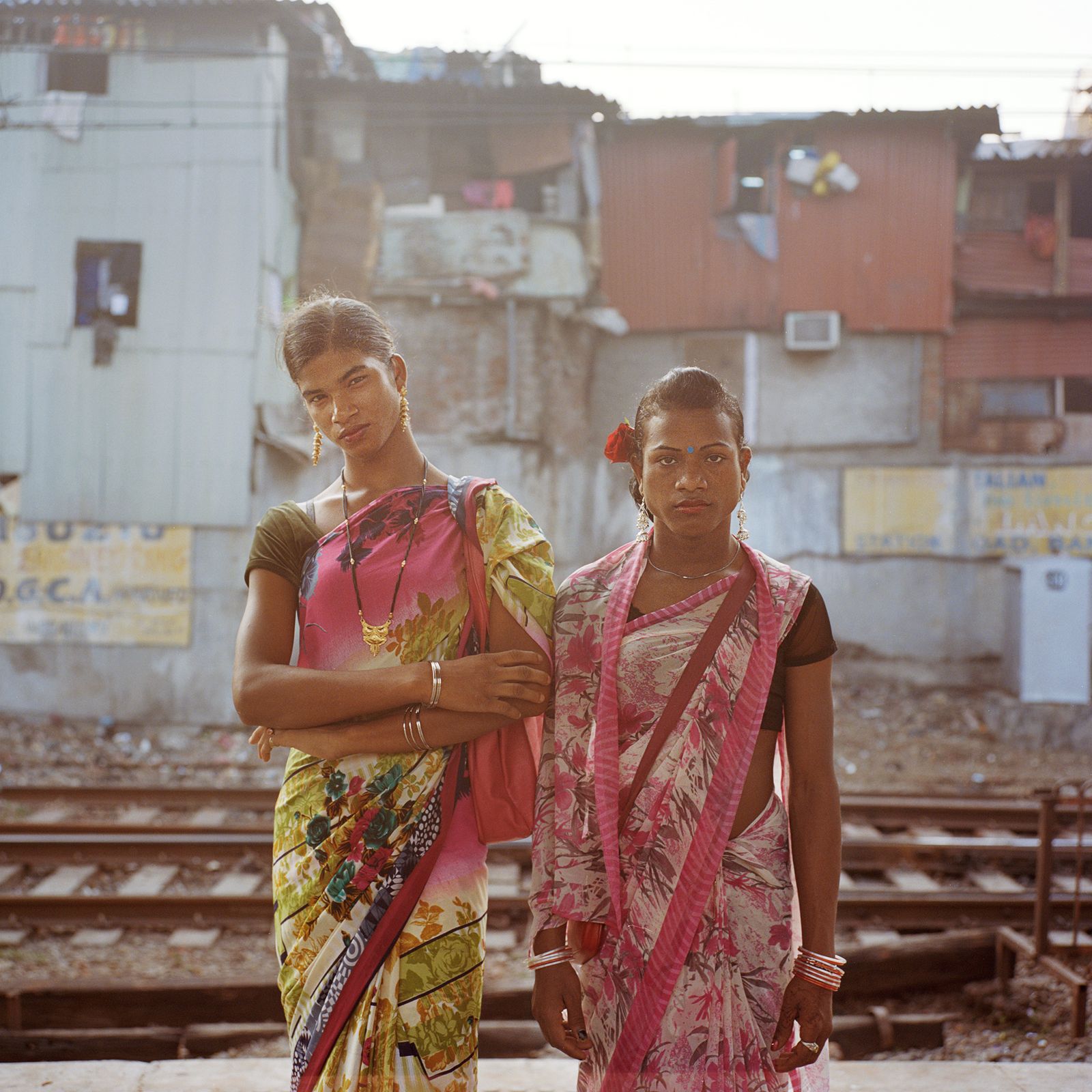 © Sara Hylton - Rajni, 20 and Puja, 23 from Orissa pose for a portrait while waiting for the train at Bandra station.
