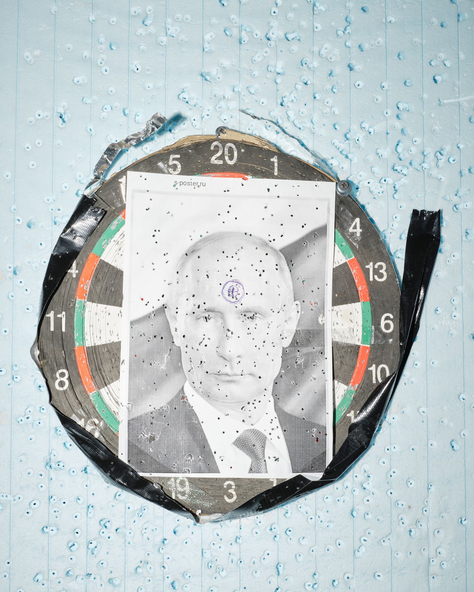 © Marcin Kruk - Lviv, 21/03/2022, A riddled photo of Putin, attached to a dart shield in one of the temporary refugee shelters in Lviv.