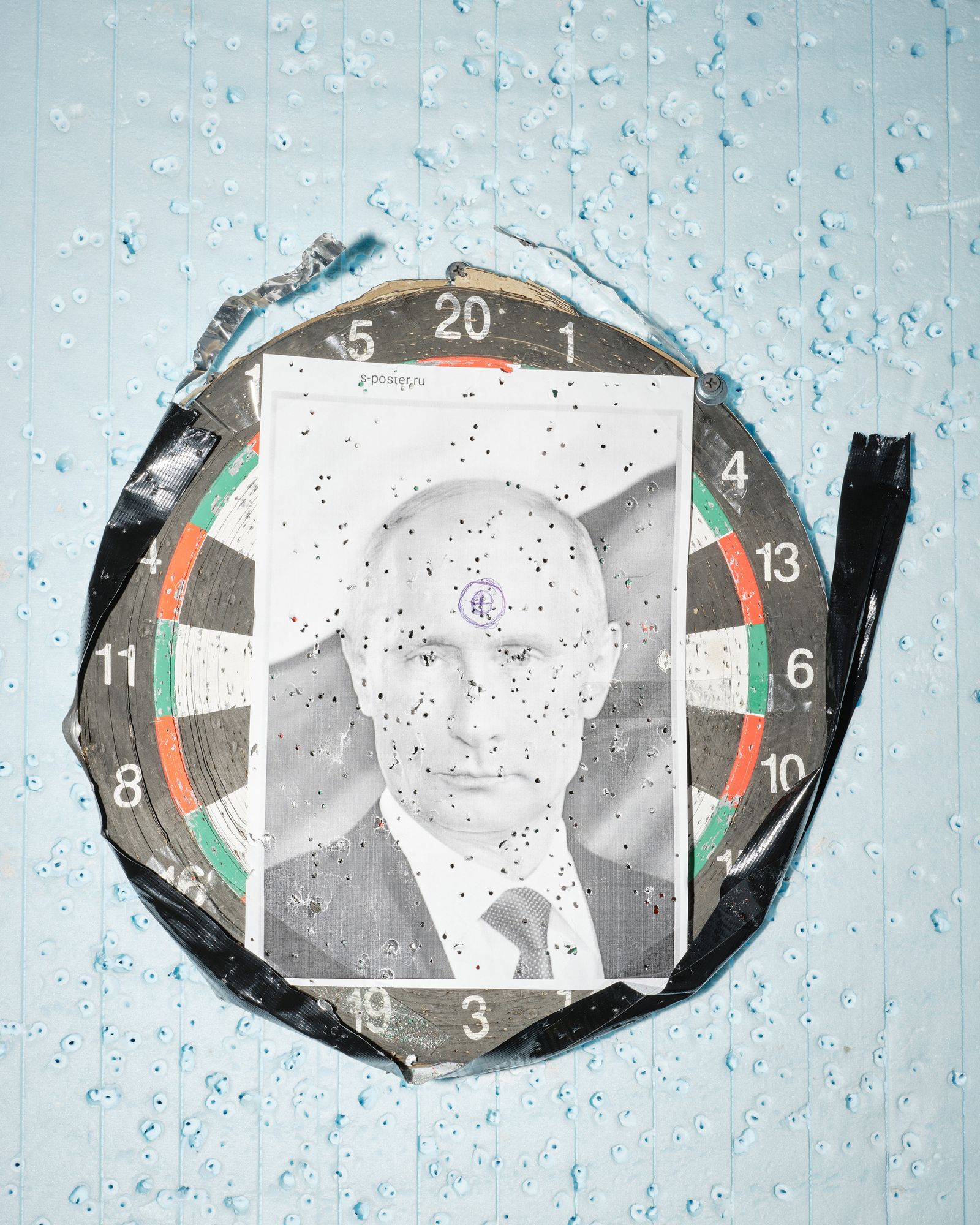 © Marcin Kruk - Lviv, 21/03/2022, A riddled photo of Putin, attached to a dart shield in one of the temporary refugee shelters in Lviv.