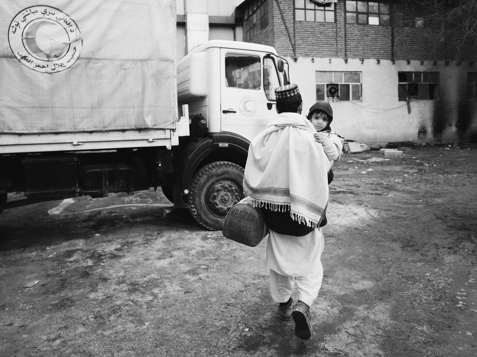 © Toby Binder - A father leaves the Red Crescent compound with his healed child.