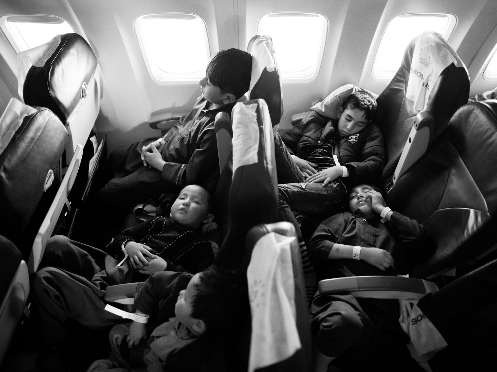 © Toby Binder - Children are falling asleep in the plane on their way to Germany.