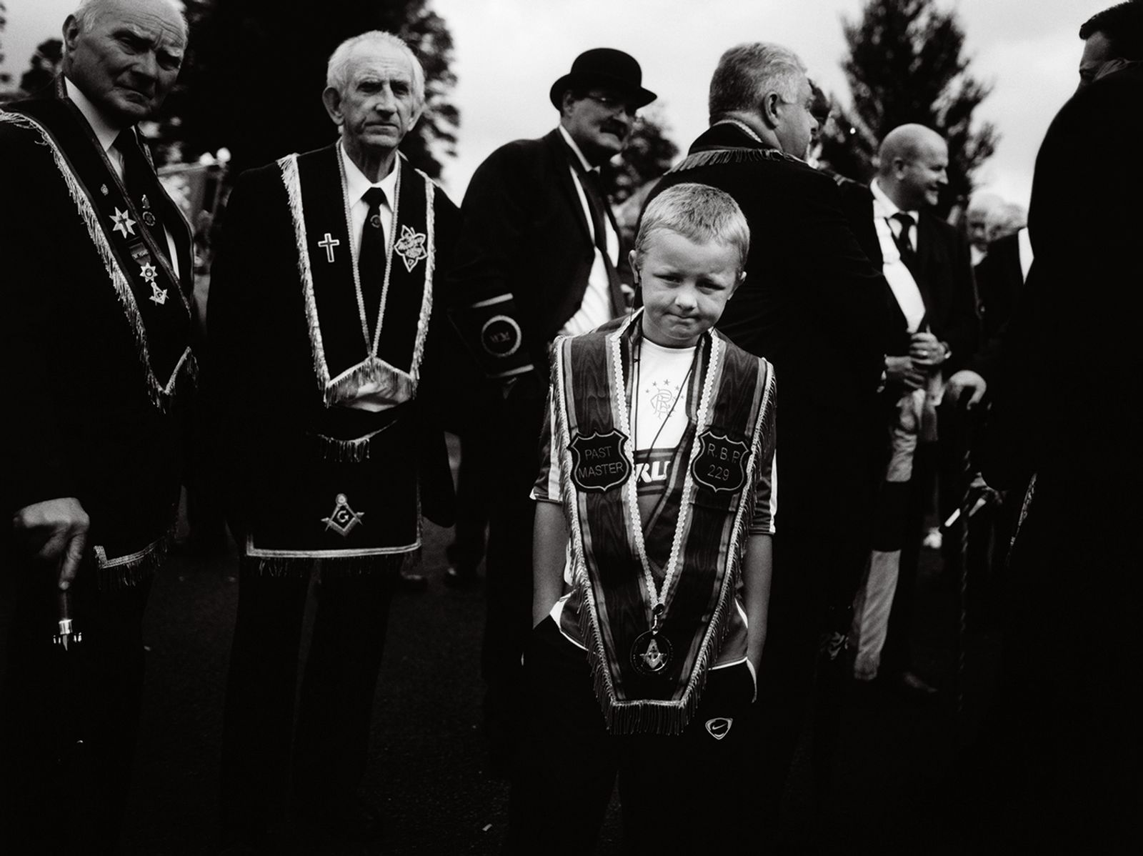 © Toby Binder - Belfast, Shankill. Young boy and old men at a Protestant parade.