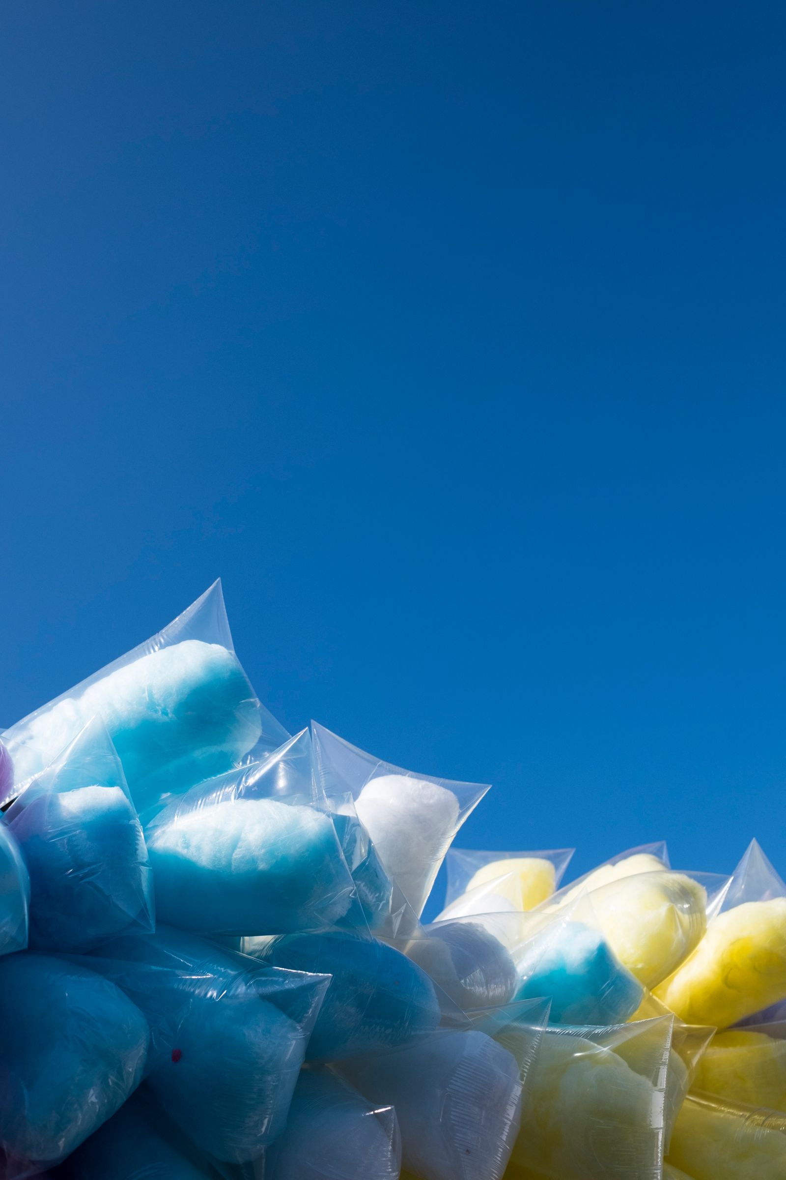 © Cris Veit - Clouds of cotton candy wrapped in plastic bags are set up against the beautiful blue sky of lake Atitlán