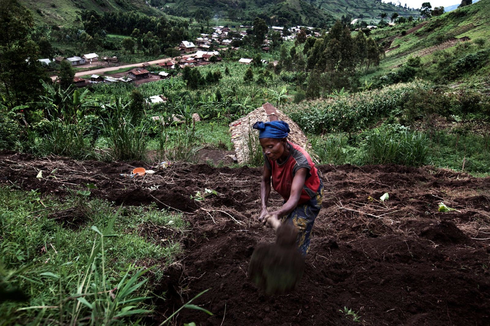 © Annibale Greco - A woman works in the fields of Buganga wih the village in the background, South Kivu province, DRC, 10 November 2011.