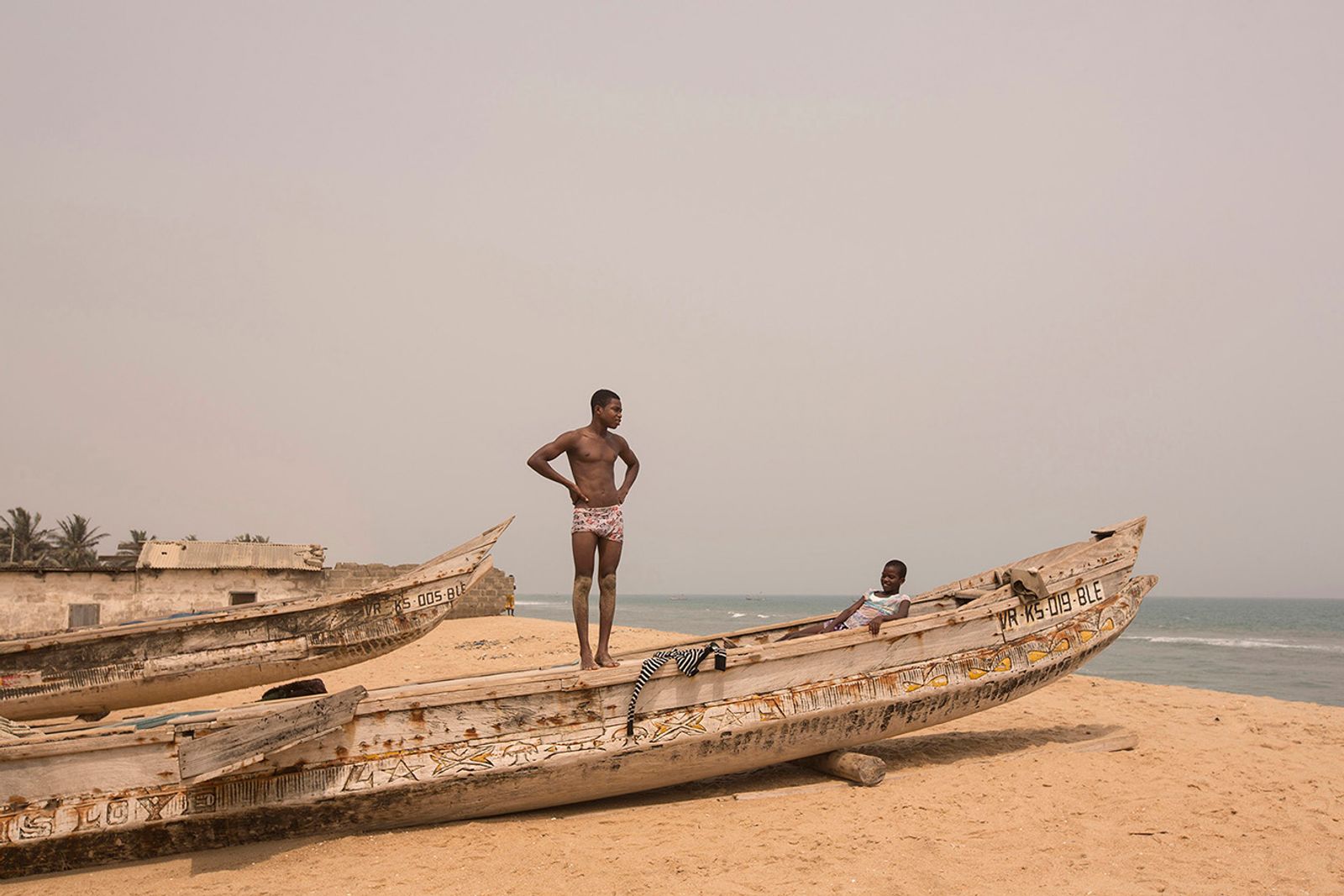 © Matilde Gattoni - Ghana - Blekusu - Young villagers stand on a traditional fishing boat.
