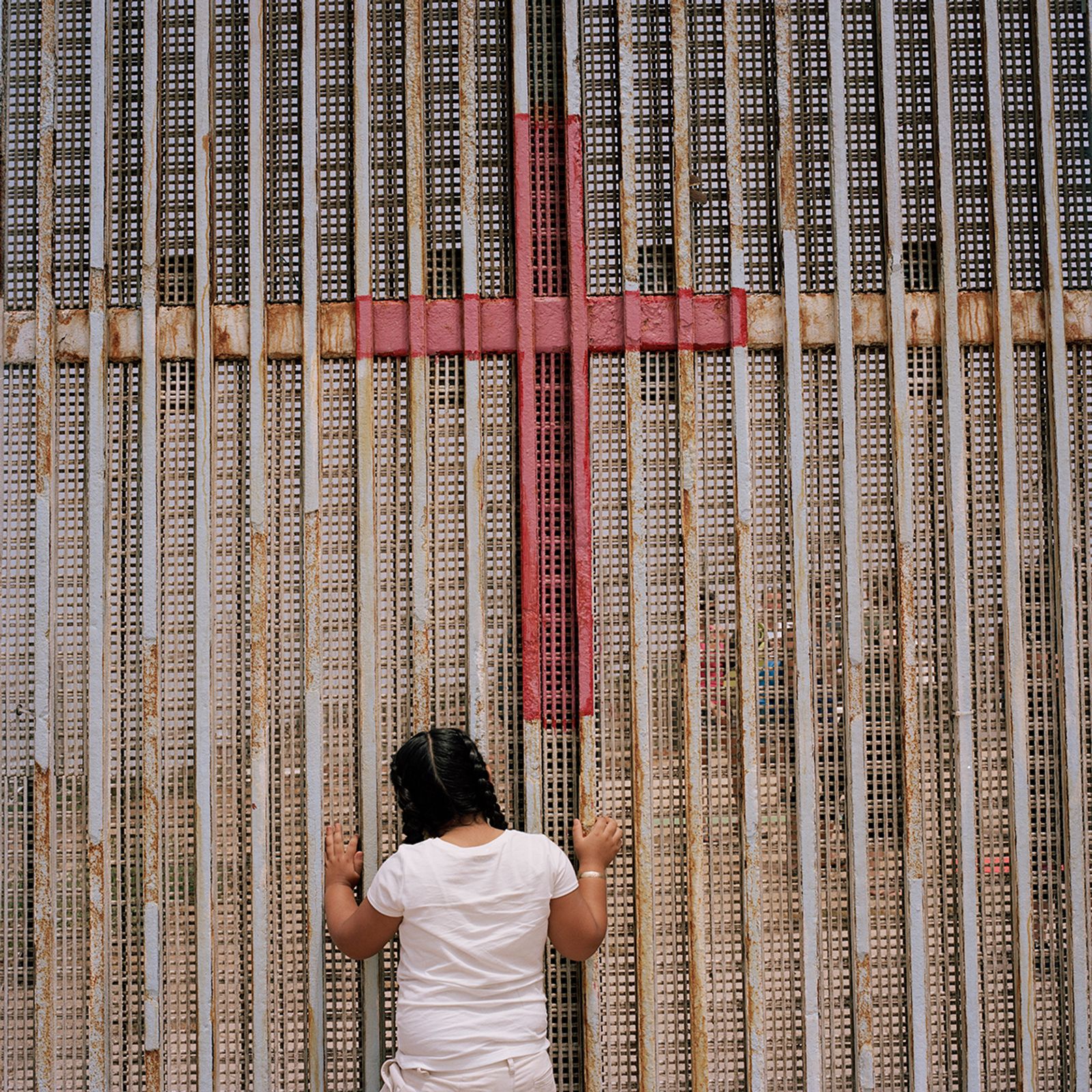 © Jordi Ruiz Cirera - A young girl watches through the border wall separating the US and Mexico in Tijuana
