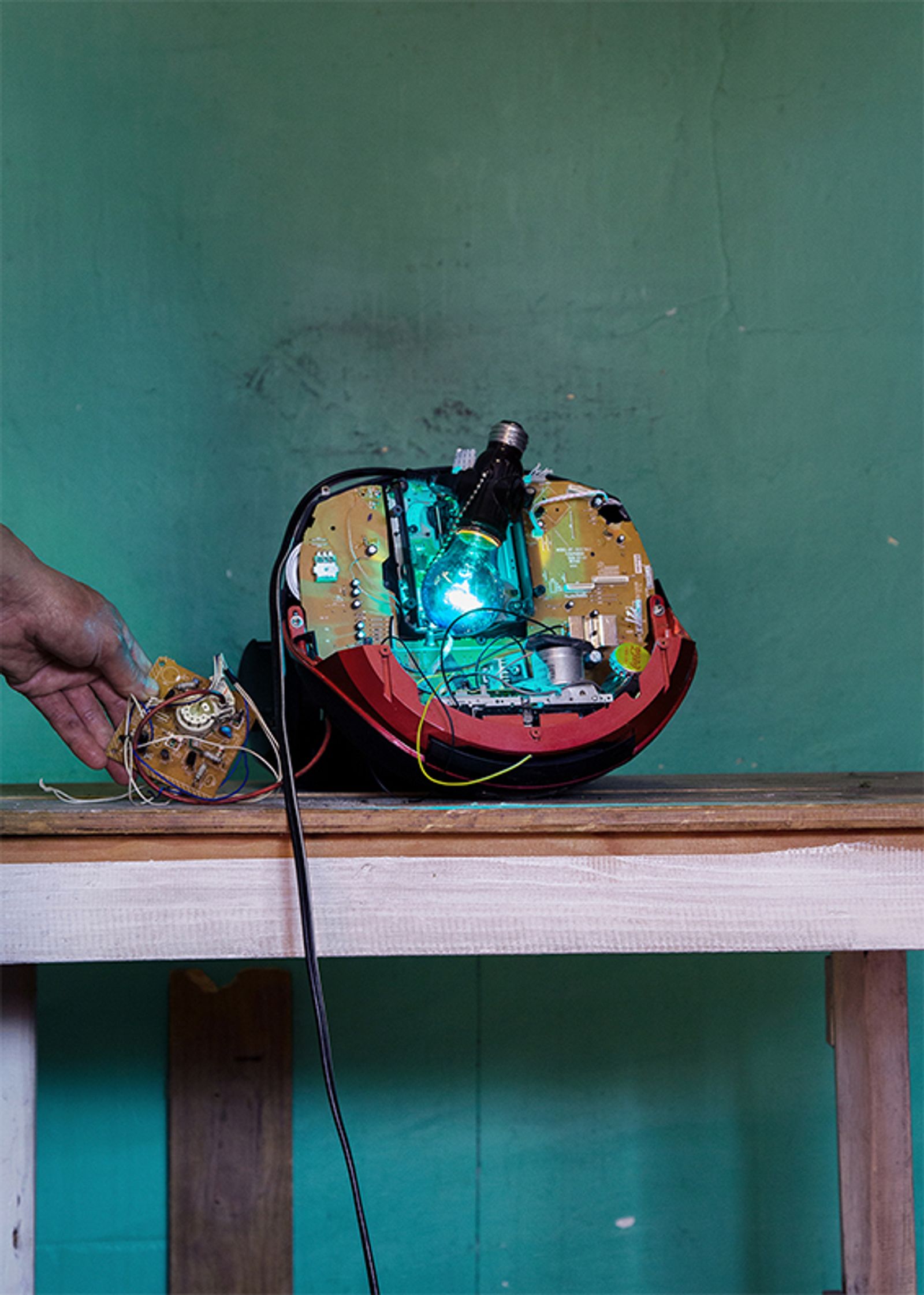 © Denis Serrano - Edmundo shows one of the radiophonic devices that he has repurposed by adding other objects into it.