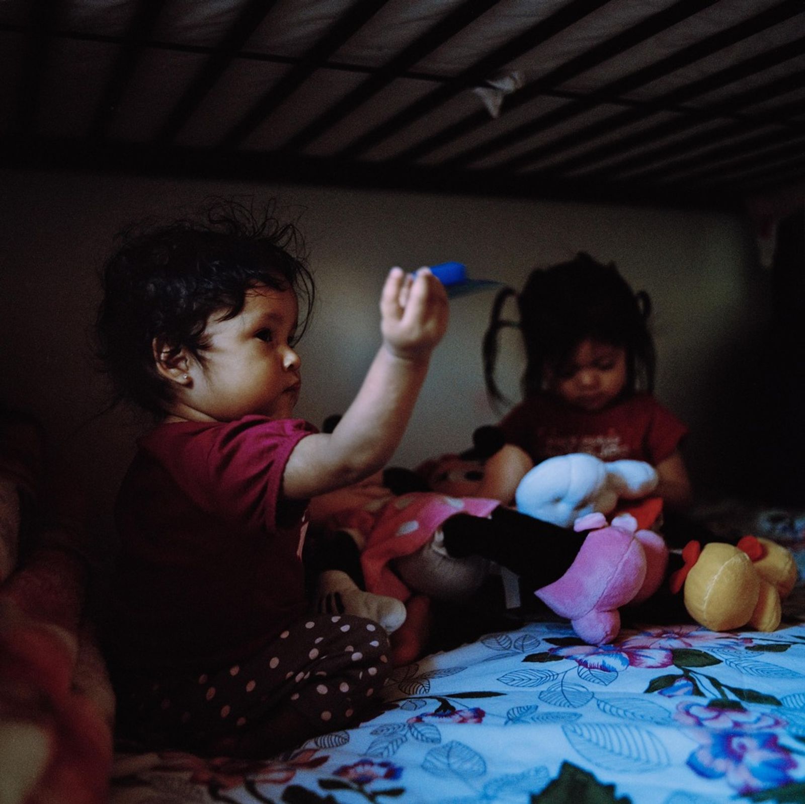 © Ruth Prieto - Sisters share the bed while playing.